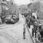 A jubilant crown meets the vehicles of 4 Division, which moved north through the village of Delden on the 4th of April 1945. Members of the Lincoln and Welland Regiment are already in town, many can be seen in the bottom right of this photo.
