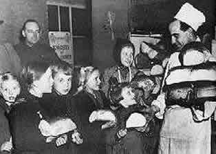 Dutch children attending a Canadian Army sponsored Christmas Party were sent home with loaves of bright white bread.