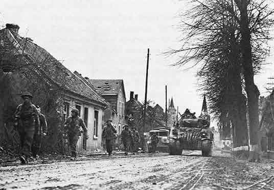 The Lincoln and Welland Regiment passes through Sonsbeck Germany on March 7th 1945.